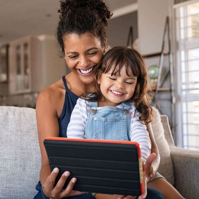 mother and daughter happily on tablet