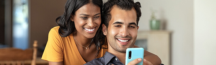 Young couple views a mobile phone