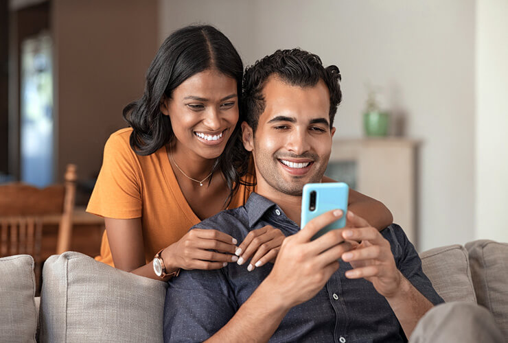 Young couple views a mobile phone