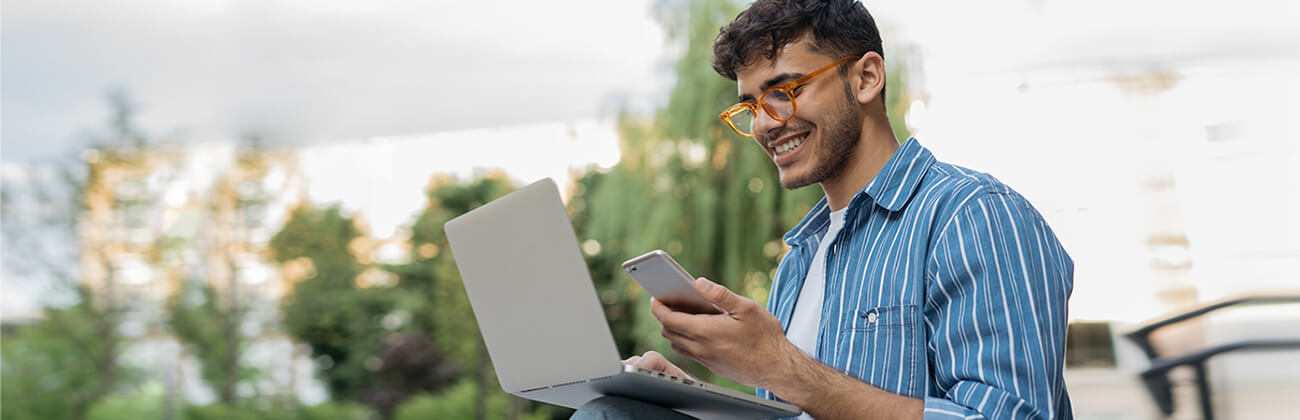 Man outdoors using mobile hotspot for his laptop