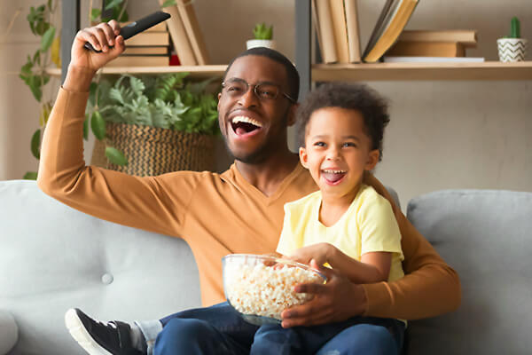 Dad and kid watch the Big Game on TV