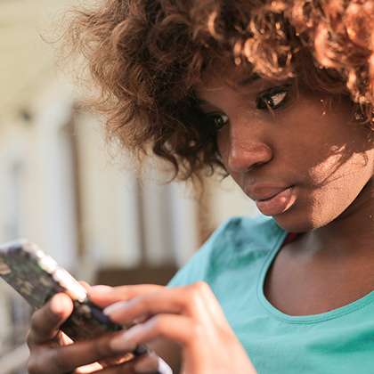 Young woman checks mobile device intently