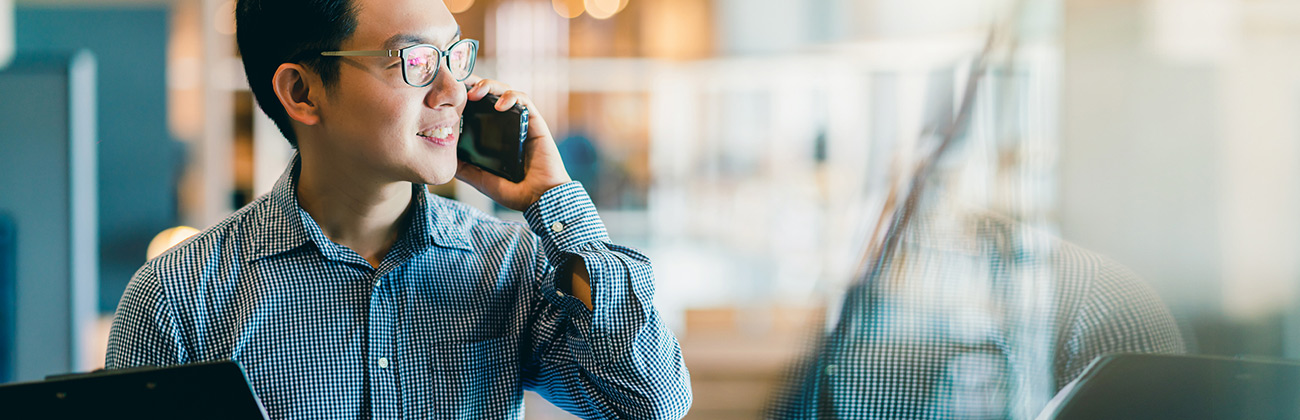 Asian man makes a cell phone call - be aware who can see your mobile data