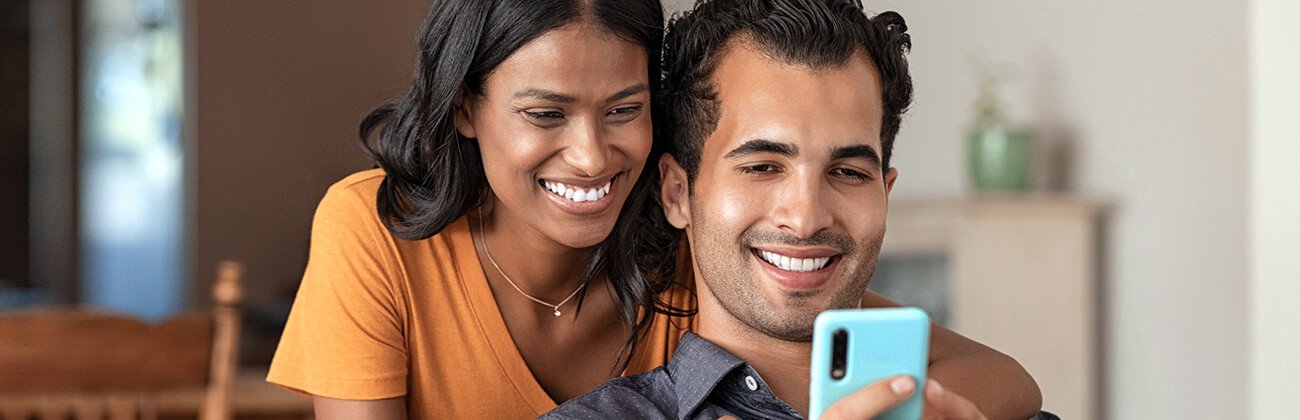 Young couple views a mobile phone