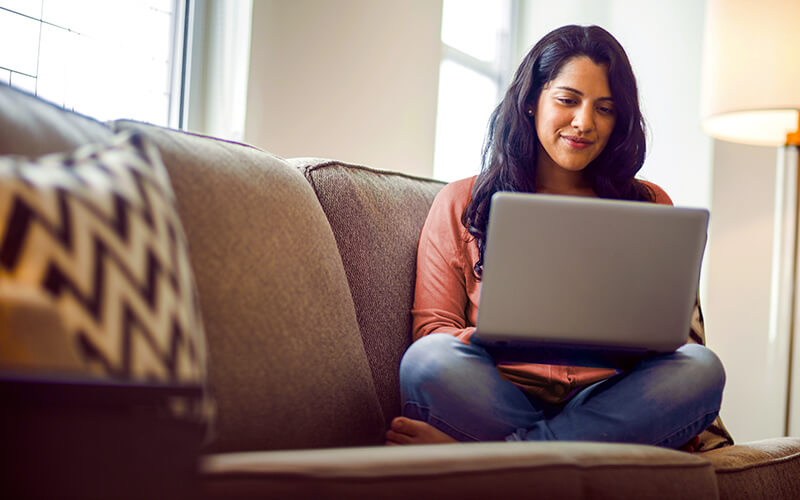 woman on a sofa using her laptop